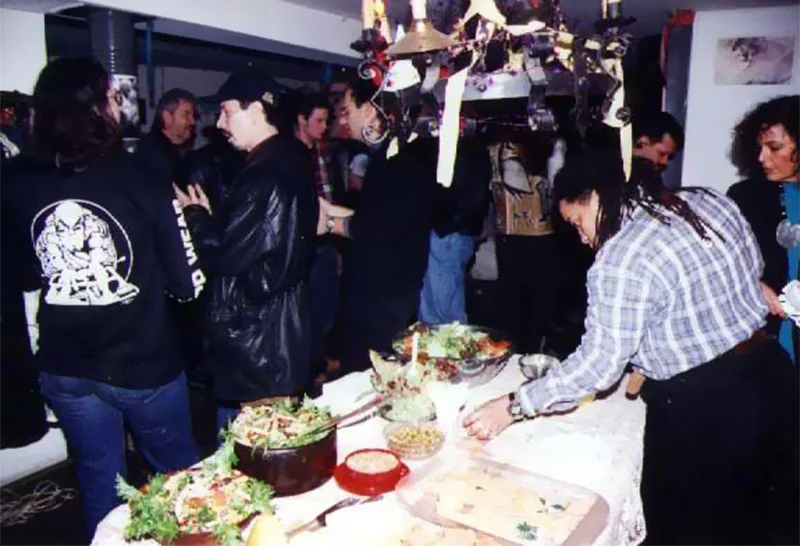 Guests helping themselves from a long table of salads and food at a Loft party.