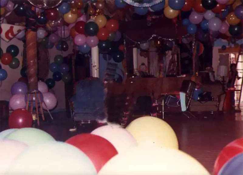 Colour snapshot of the Prince Street loft before a party: clusters of balloons hang from the ceiling over an empty dance floor.