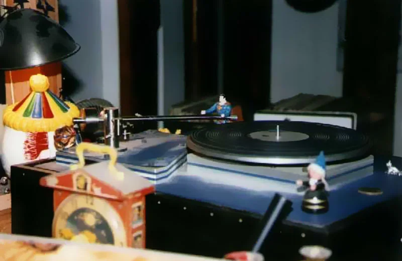 A turntable in the Loft's booth, crowded with toys — a clown, a mushroom lamp, small figures — beside a cuckoo clock.